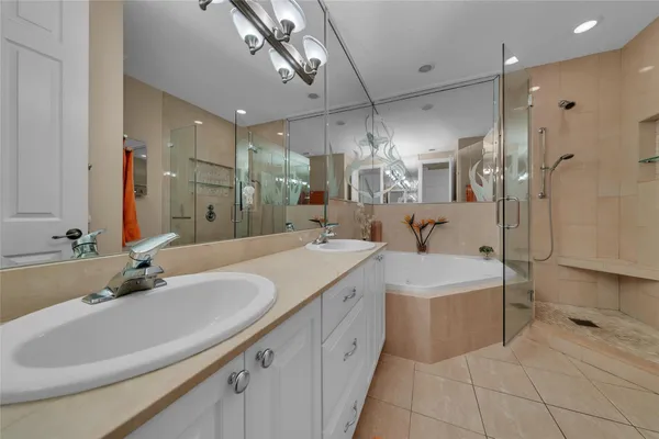 a bathroom with a double vanity sink mirror and shower