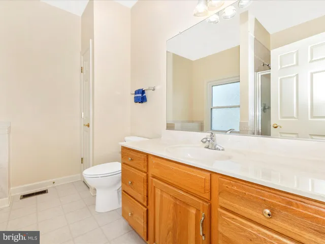 a bathroom with a granite countertop sink a toilet and a mirror