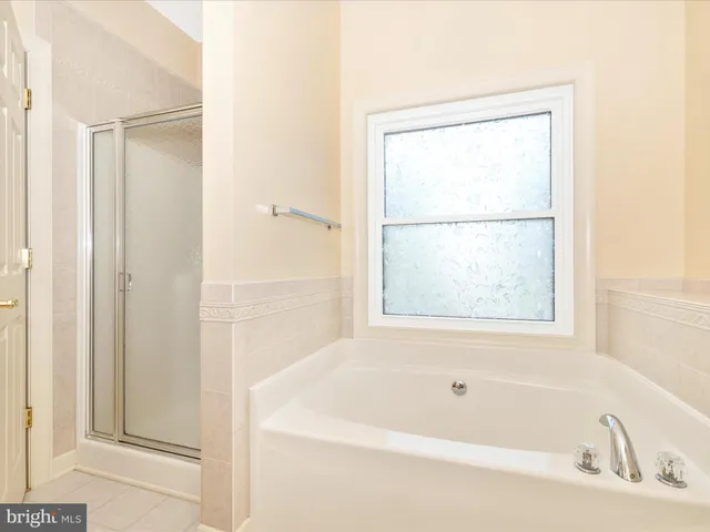 a white bath tub sitting next to a shower
