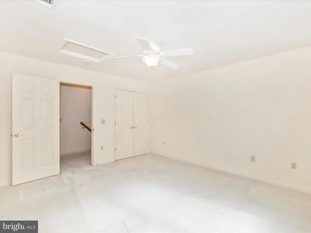 an empty room with a ceiling fan and a window
