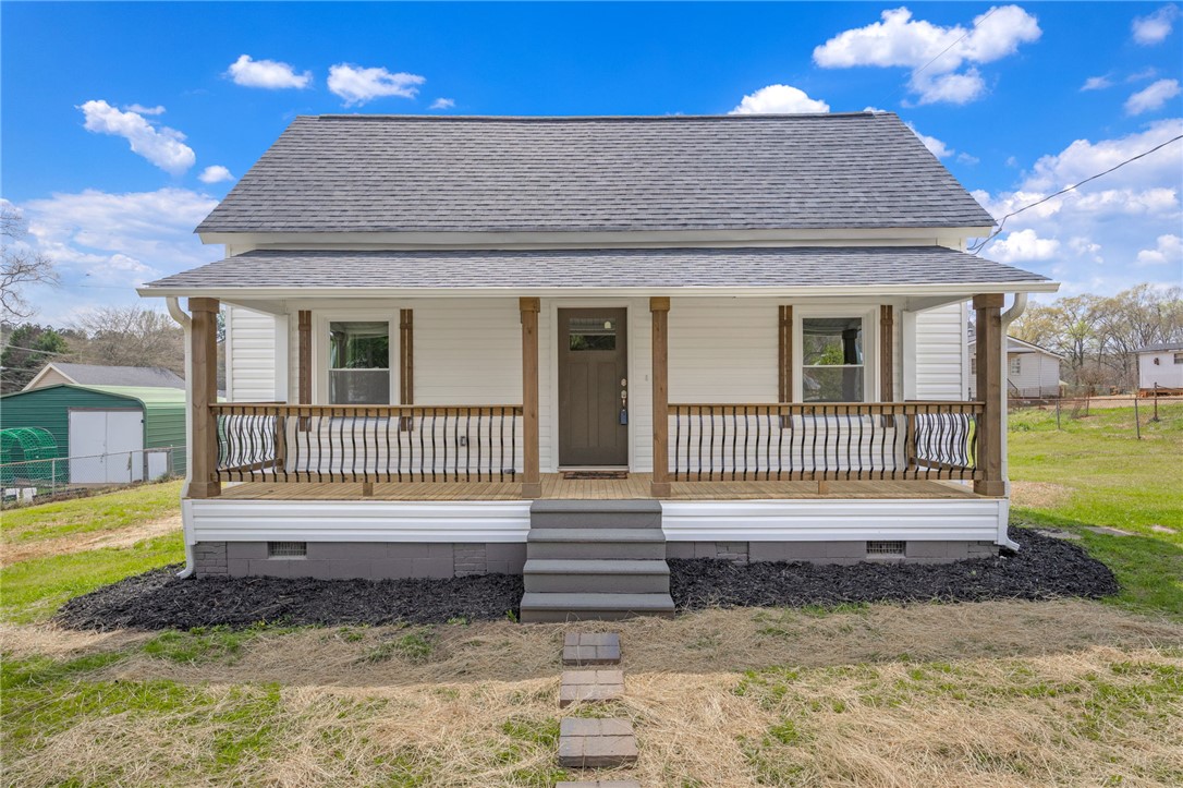This charming home features a welcoming porch, perfect for enjoying peaceful outdoor moments.