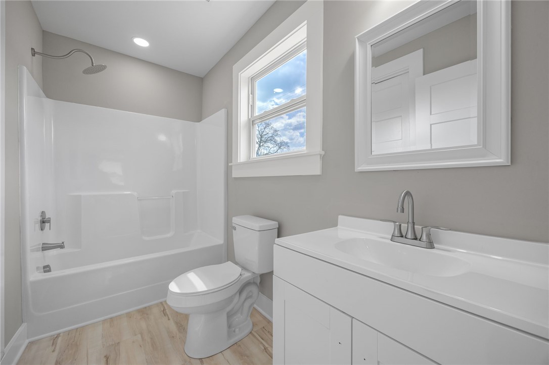 2 Allen Street Pelzer, SC 29669 - Photo 14 of 25 This bright bathroom features a vanity, bathtub, and natural light, creating a serene atmosphere.