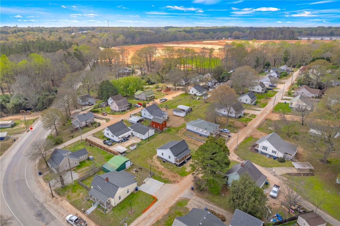 2 Allen Street Pelzer, SC 29669 - Photo 23 of 25 An aerial view showcases a residential community nestled amidst lush trees and open fields.