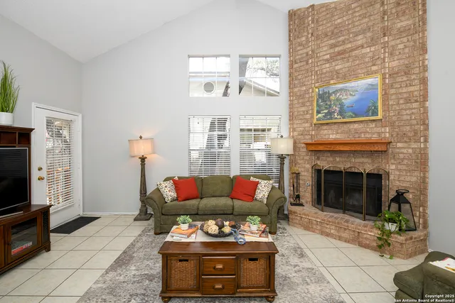 a living room with furniture a flat screen tv and a fireplace