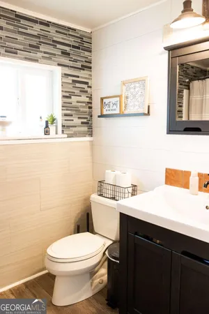 a bathroom with a sink a toilet and a window