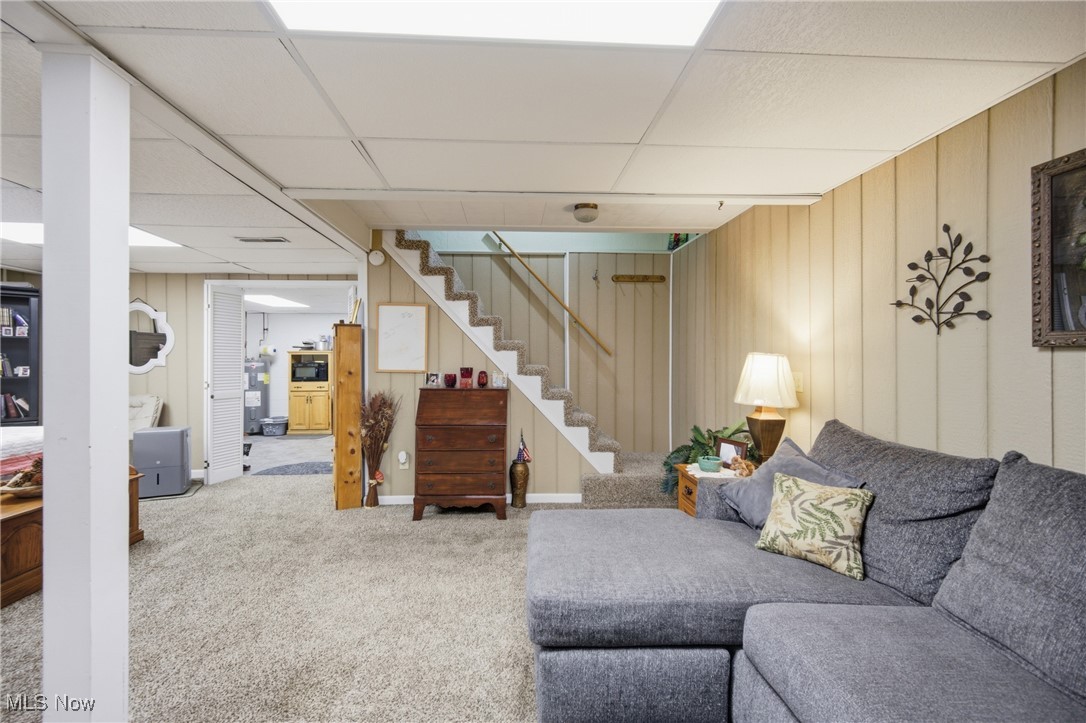 1788 Ashby Ridge Road Parkersburg, WV 26104 - Photo 32 of 46 Living area featuring carpet floors, a drop ceiling, stairs, and wood walls