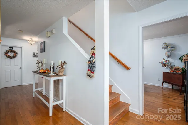 a view of a livingroom with wooden floor and stairs