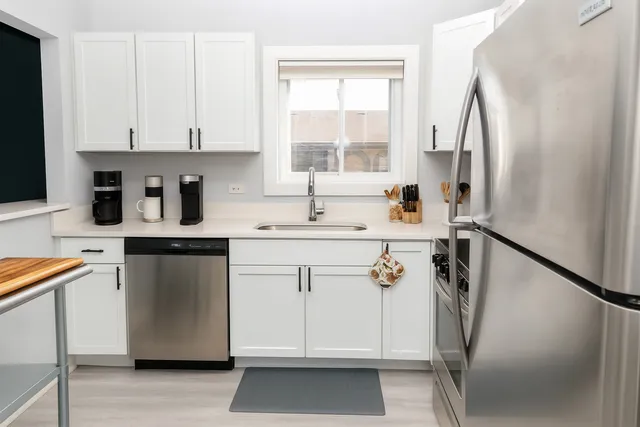 a kitchen with stainless steel appliances a refrigerator sink and cabinets