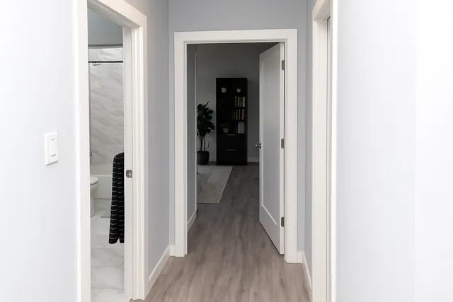 a view of a hallway with wooden floor