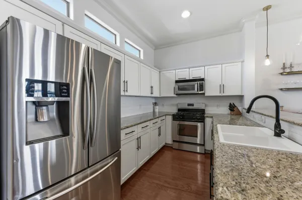 a kitchen with stainless steel appliances granite countertop a refrigerator sink and stove