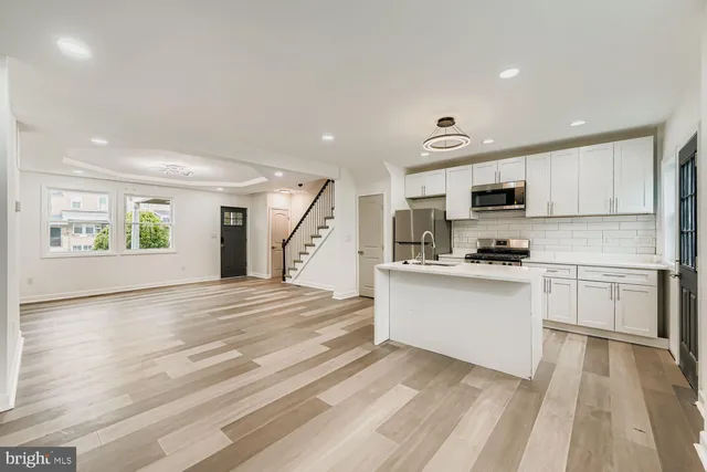 a kitchen with granite countertop white cabinets and appliances