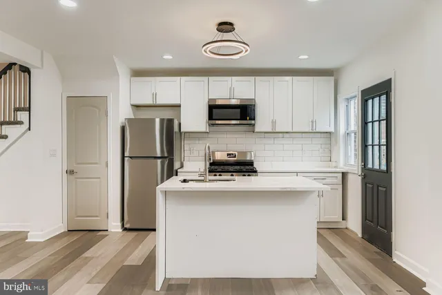 a kitchen with a refrigerator and a stove top oven
