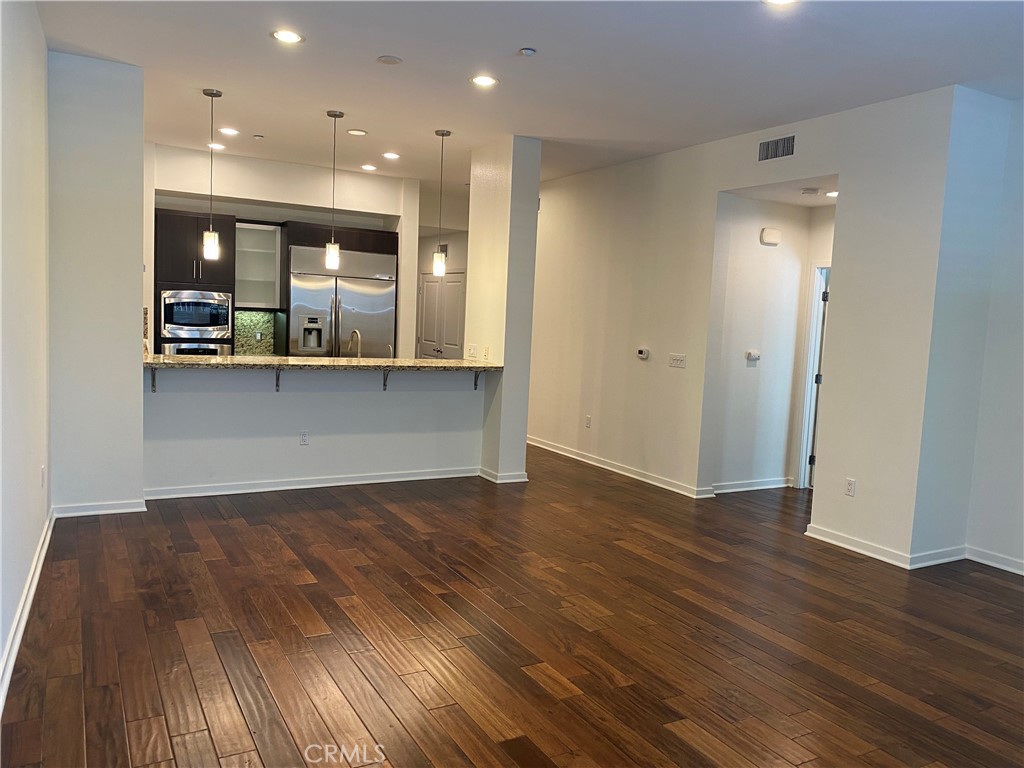 21 Gramercy, Unit 116 Irvine, CA 92612 - Photo 2 of 9 an empty room with wooden floor and windows