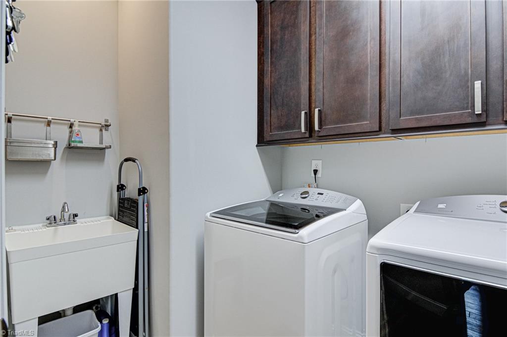634 Nikyle Circle High Point, NC 27265 - Photo 25 of 32 The laundry room with cabinetry for storage, laundry sink and vinyl flooring. The washer and dryer will convey with the home.