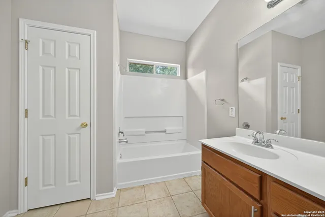 a view of a big room with wooden floor a ceiling fan and windows