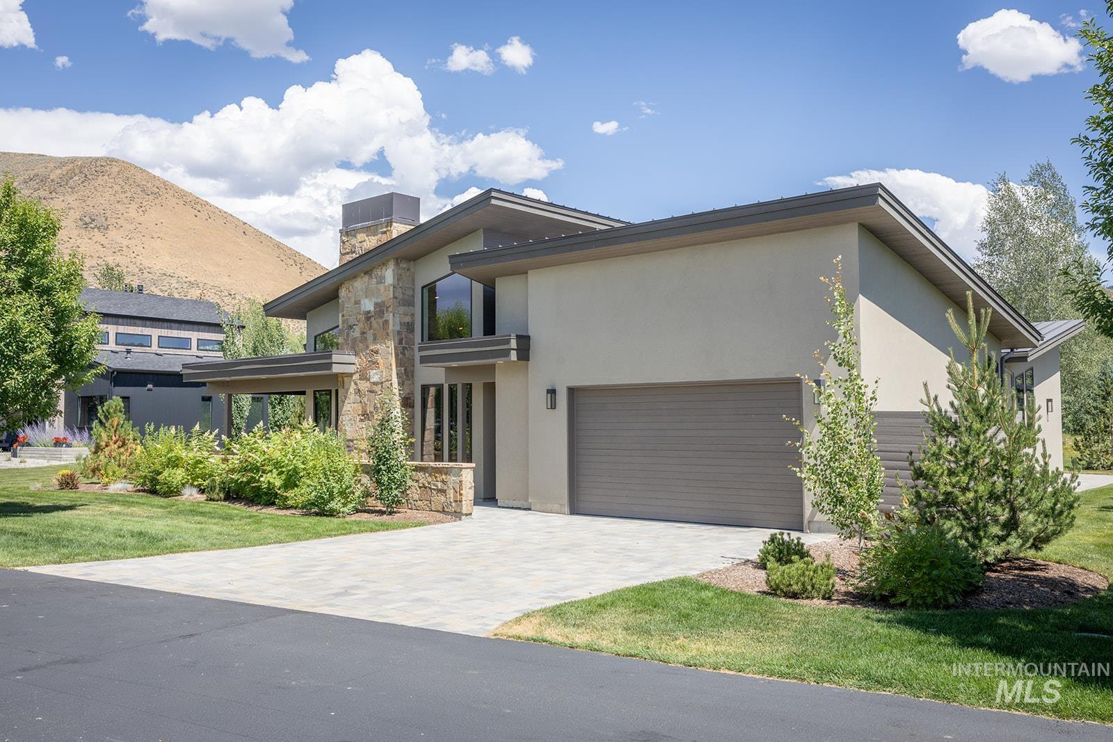 27 Streamside Drive Hailey, ID 83333 - Photo 31 of 39 Modern home with stone siding, stucco siding, a garage, and decorative driveway