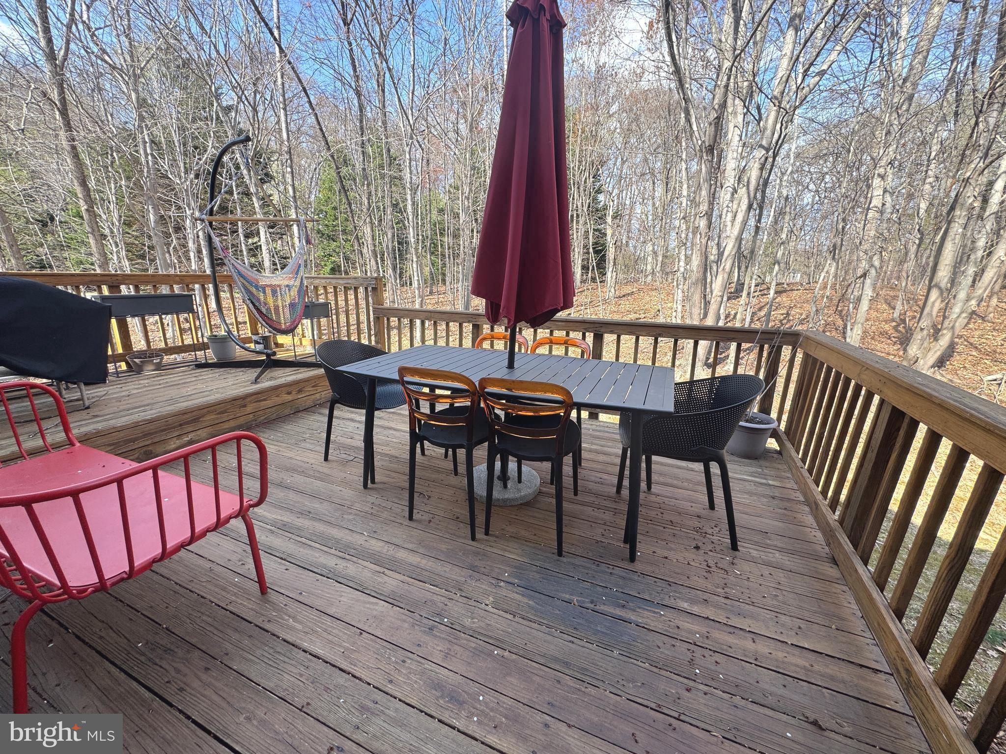 8732 Stone Hill Place Springfield, VA 22153 - Photo 27 of 28 a view of a roof deck with table and chairs with wooden floor and fence