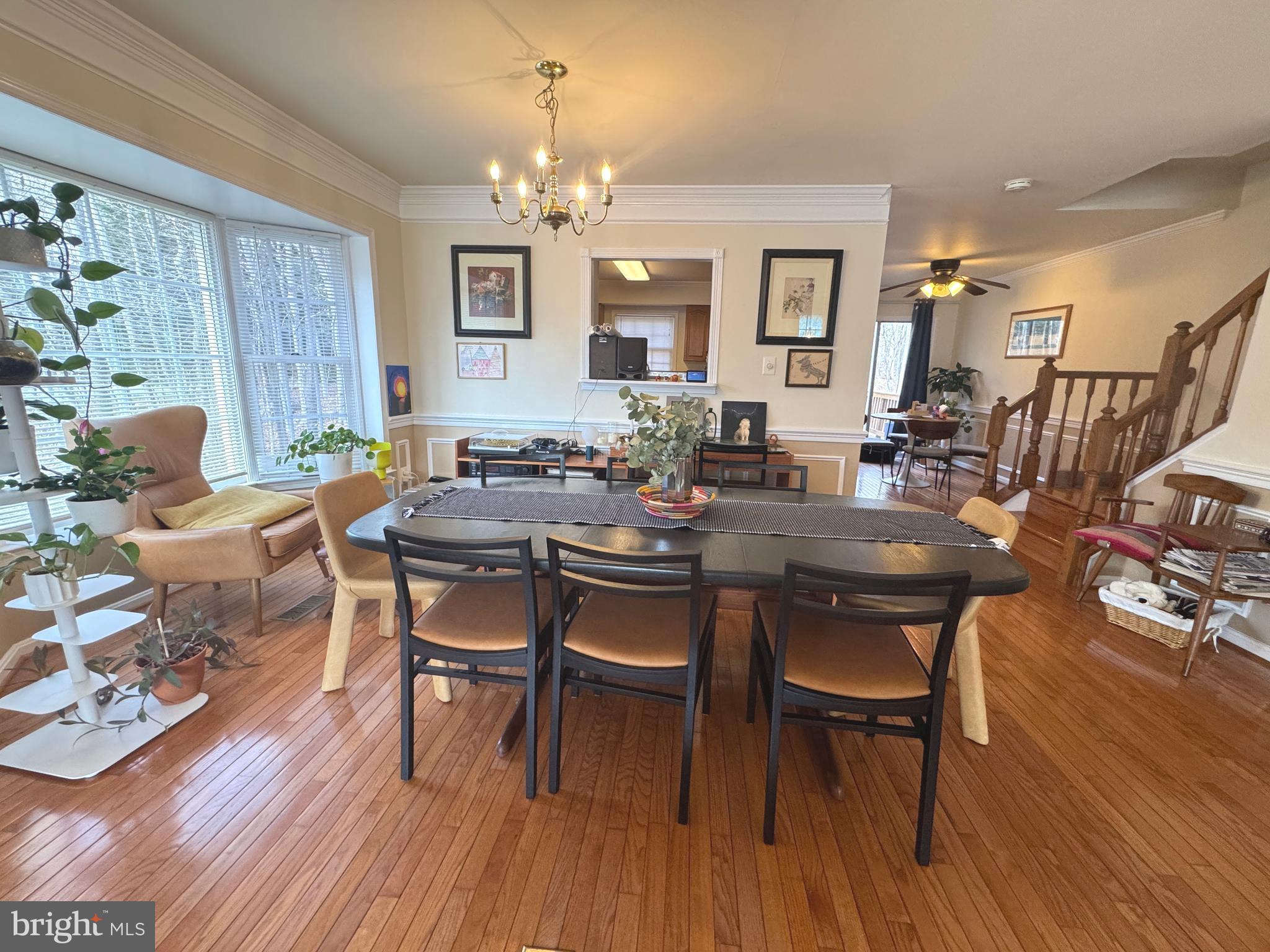 8732 Stone Hill Place Springfield, VA 22153 - Photo 7 of 28 a dining room with wooden floor a chandelier a wooden table and chairs