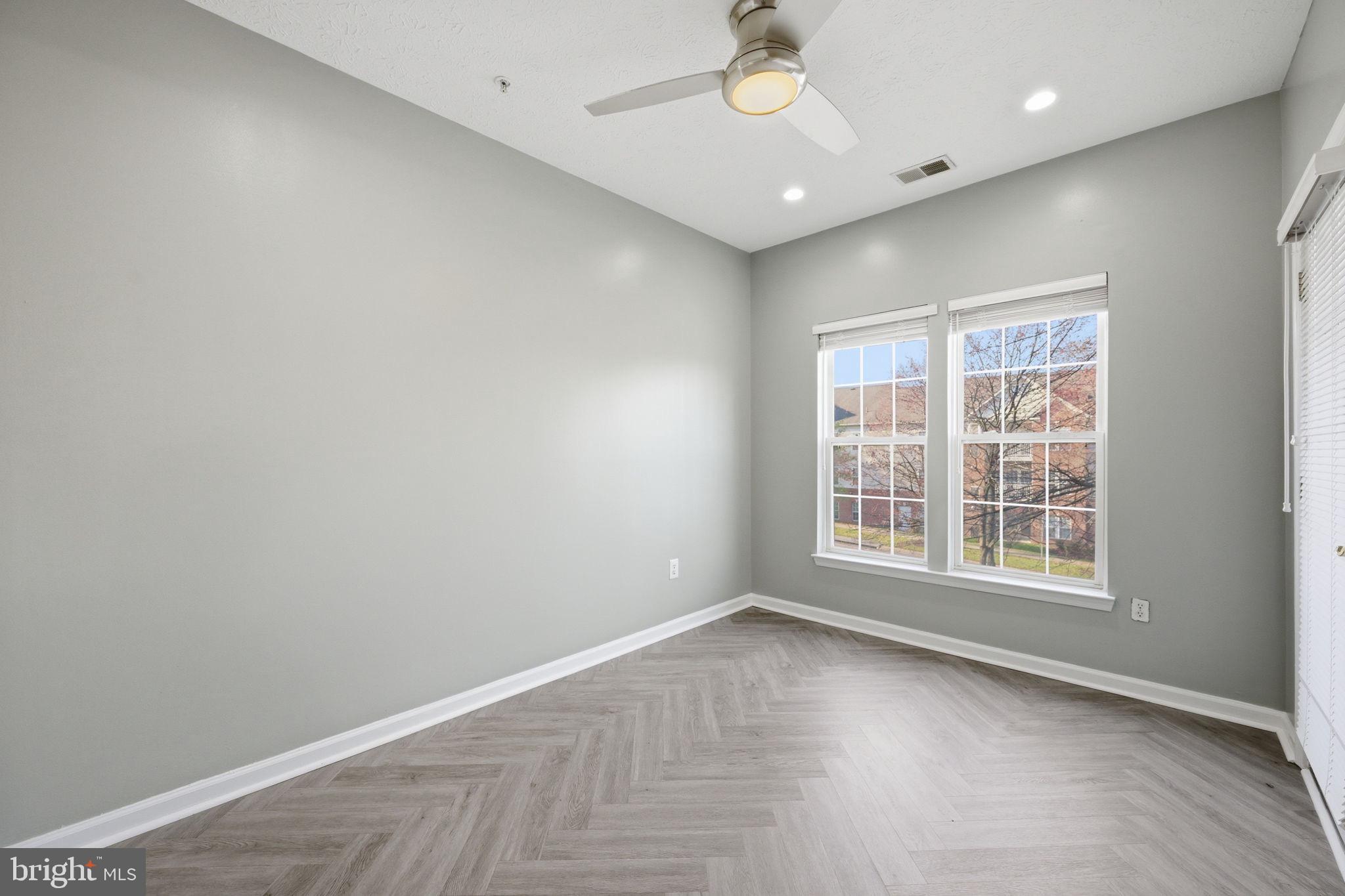2402 Chestnut Terrace Court, Unit 202 Odenton, MD 21113 - Photo 11 of 24 an empty room with wooden floor and windows