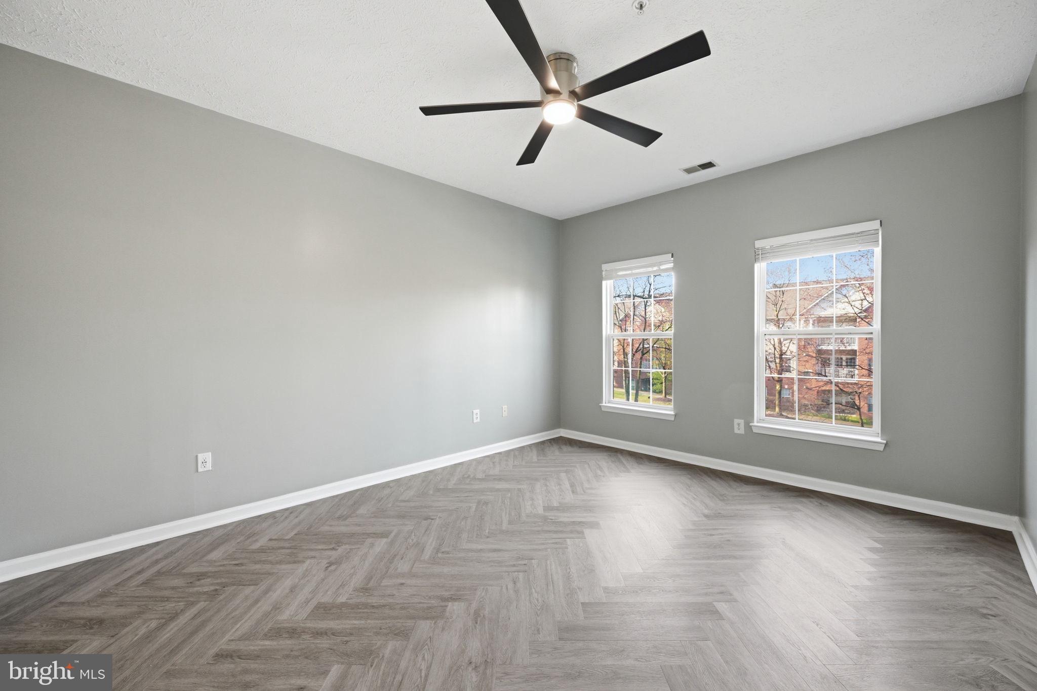 2402 Chestnut Terrace Court, Unit 202 Odenton, MD 21113 - Photo 13 of 24 an empty room with wooden floor and windows