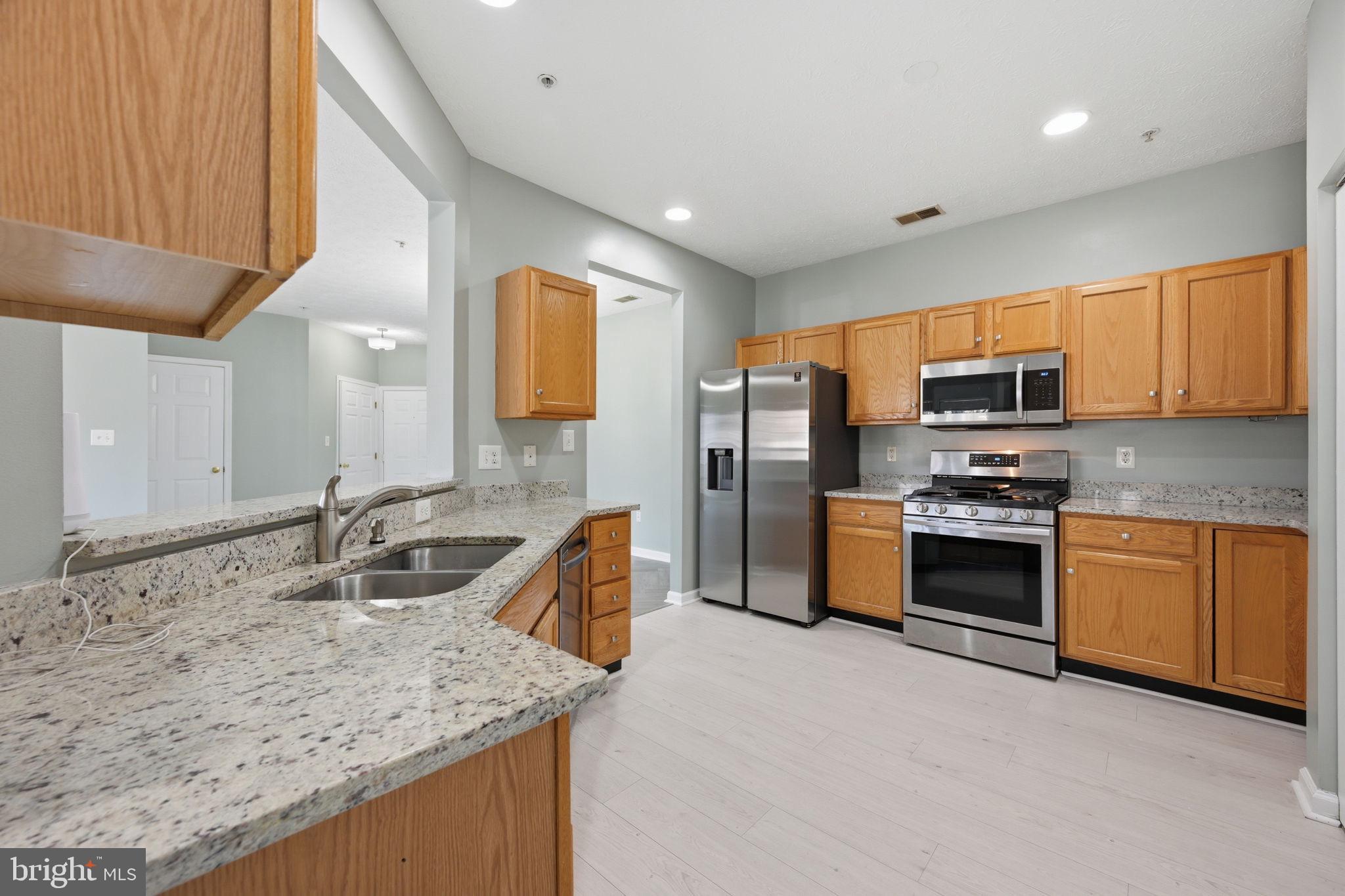 2402 Chestnut Terrace Court, Unit 202 Odenton, MD 21113 - Photo 2 of 24 a kitchen with stainless steel appliances granite countertop a sink stove and refrigerator