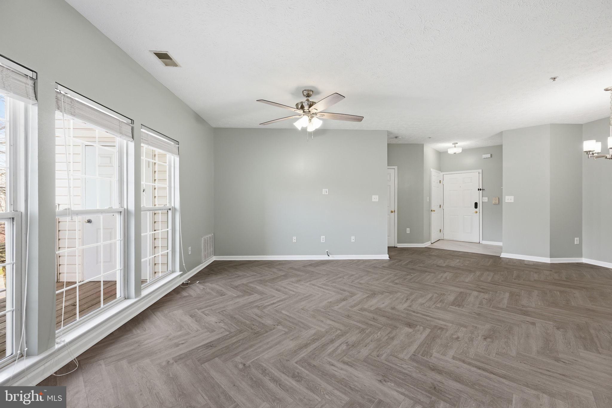 2402 Chestnut Terrace Court, Unit 202 Odenton, MD 21113 - Photo 7 of 24 a view of an empty room with chandelier fan and windows