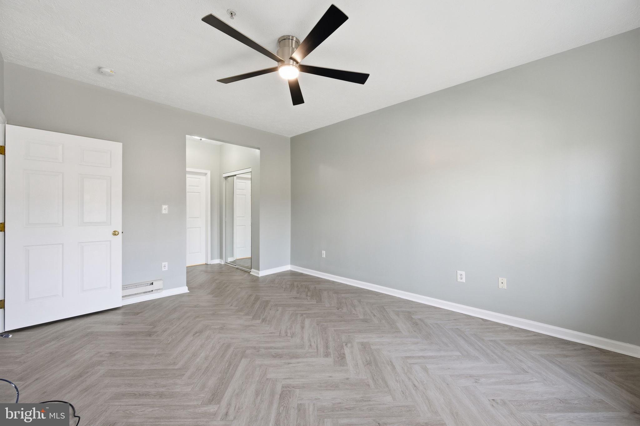 2402 Chestnut Terrace Court, Unit 202 Odenton, MD 21113 - Photo 10 of 24 an empty room with ceiling fan and windows