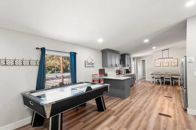 a room with a table chairs and a open kitchen view
