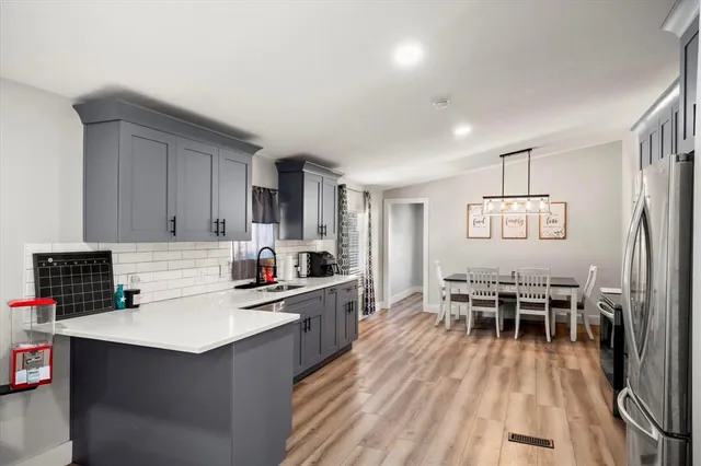 a kitchen with a dining table chairs stove refrigerator and cabinets
