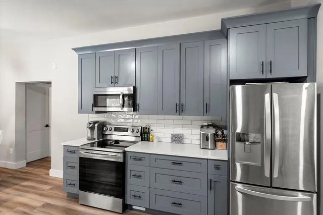 a kitchen with stainless steel appliances granite countertop a refrigerator stove and sink