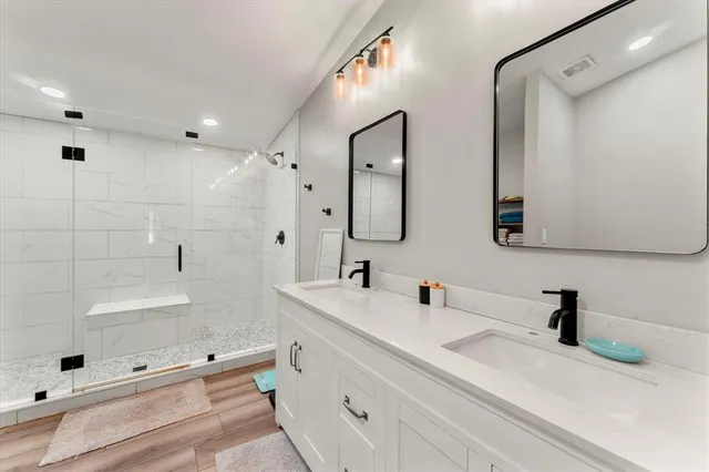 a bathroom with double vanity sink and mirror