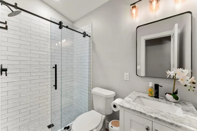 a bathroom with a granite countertop sink toilet and shower