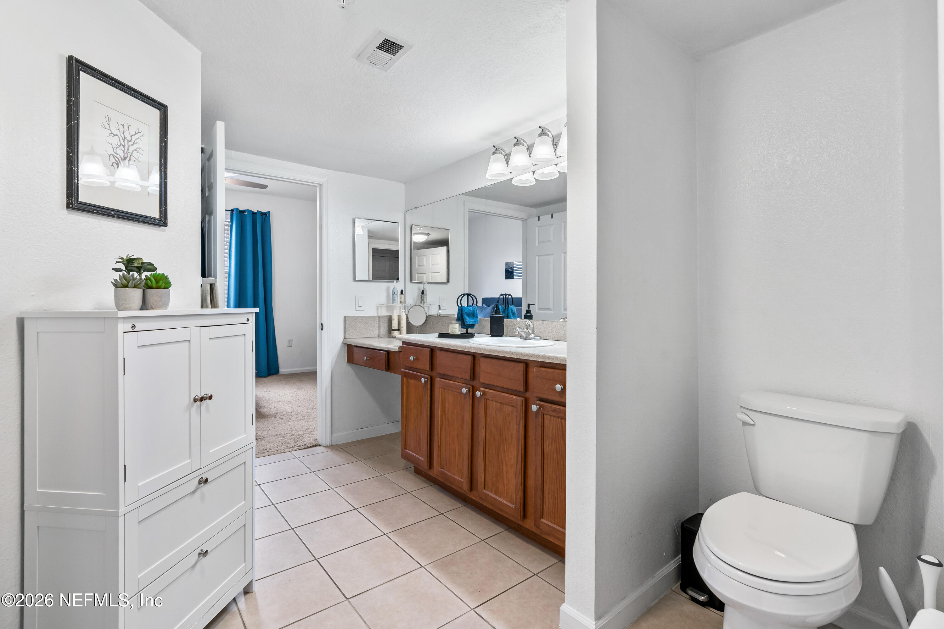 8550 Touchton Road, Unit 1034 Jacksonville, FL 32216 - Photo 14 of 30 a room with a sink a toilet and a mirror