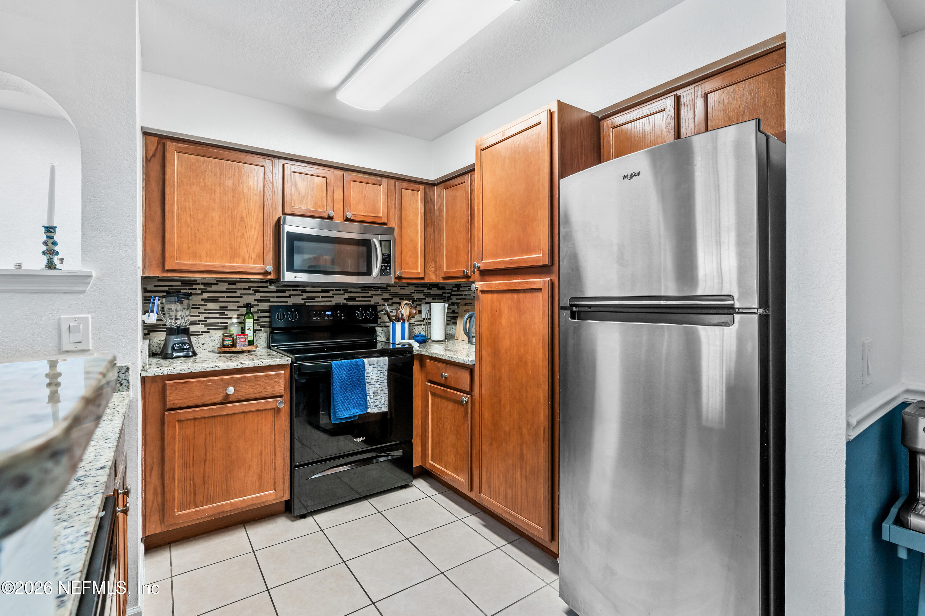8550 Touchton Road, Unit 1034 Jacksonville, FL 32216 - Photo 7 of 30 a kitchen with stainless steel appliances granite countertop a refrigerator stove and microwave