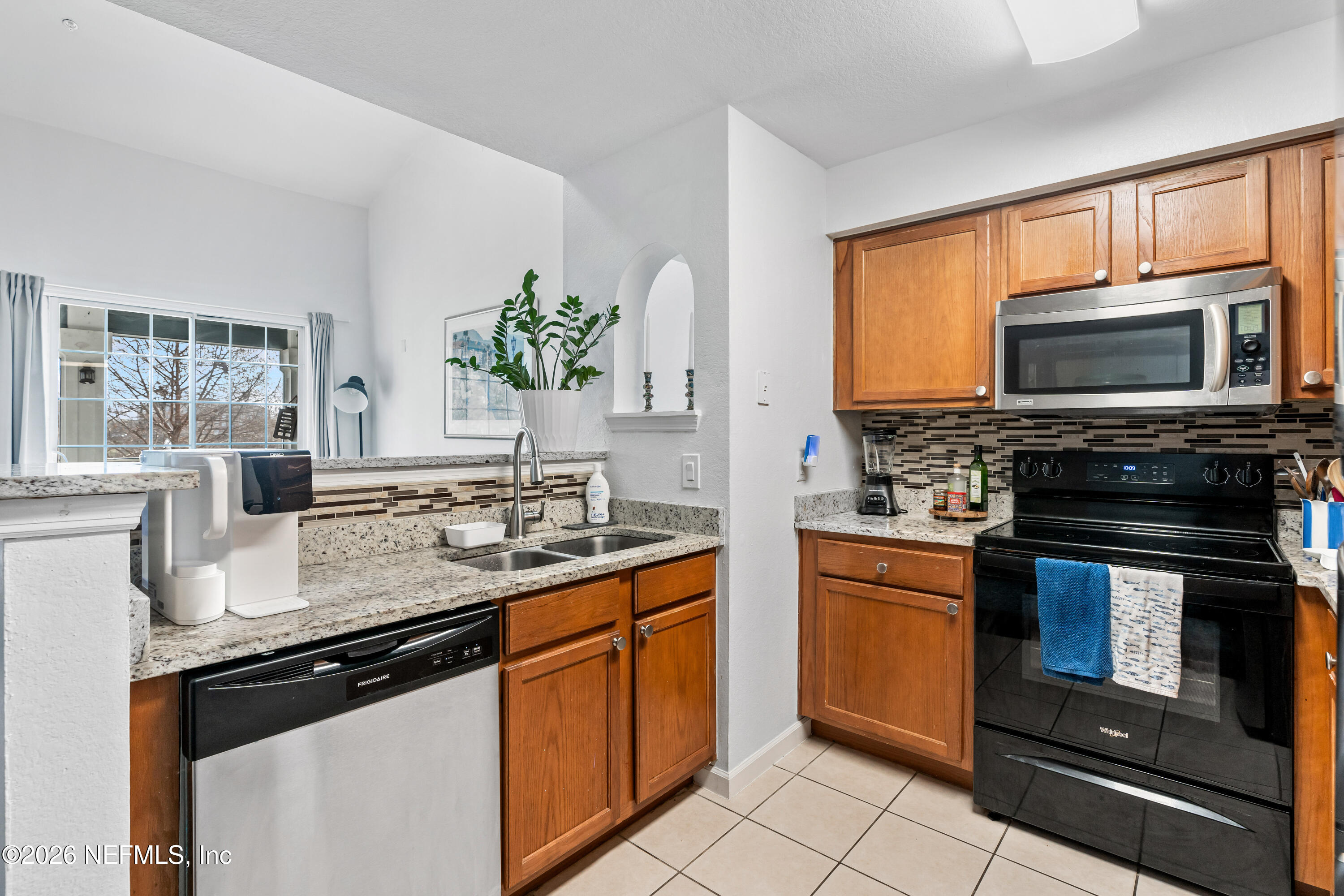 8550 Touchton Road, Unit 1034 Jacksonville, FL 32216 - Photo 8 of 30 a kitchen with stainless steel appliances granite countertop a sink stove microwave and refrigerator