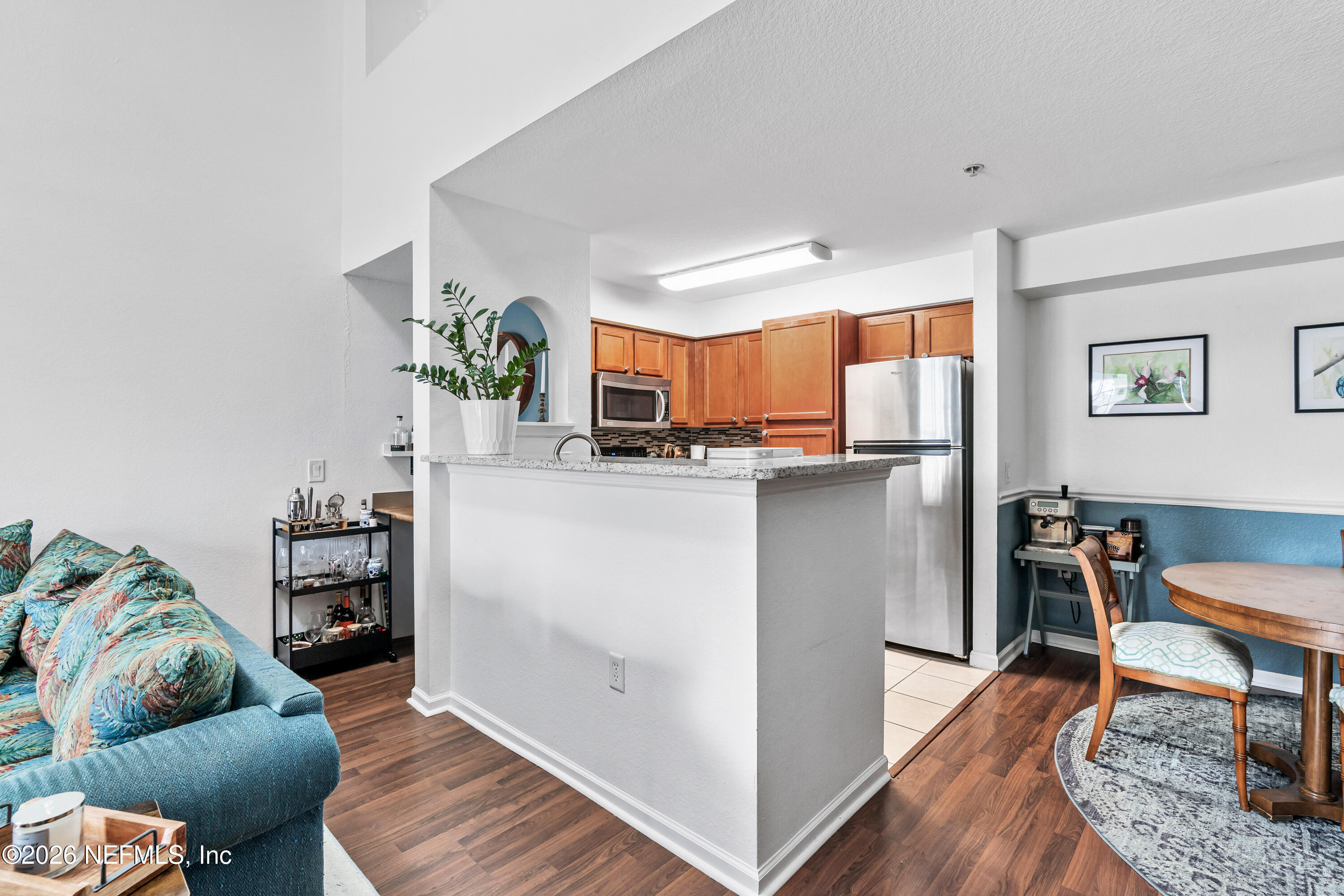 8550 Touchton Road, Unit 1034 Jacksonville, FL 32216 - Photo 9 of 30 a living room with a couch and a dining table with wooden floor