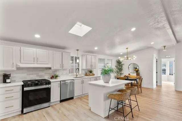 a living room with furniture kitchen view and a chandelier