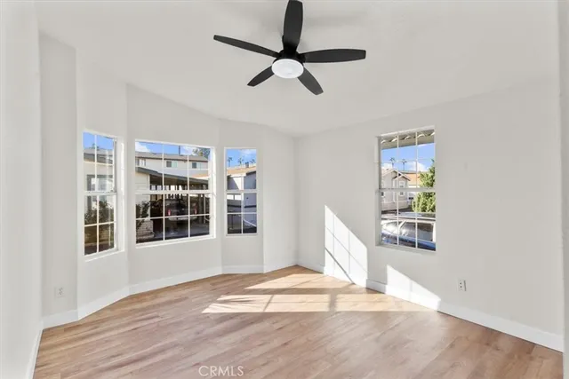 a view of an empty room with wooden floor and windows