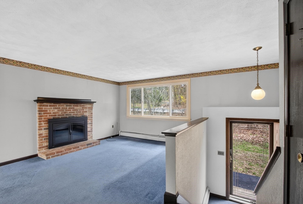 73 Nashua Road Pepperell, MA 01463 - Photo 4 of 33 an empty room with windows and fireplace