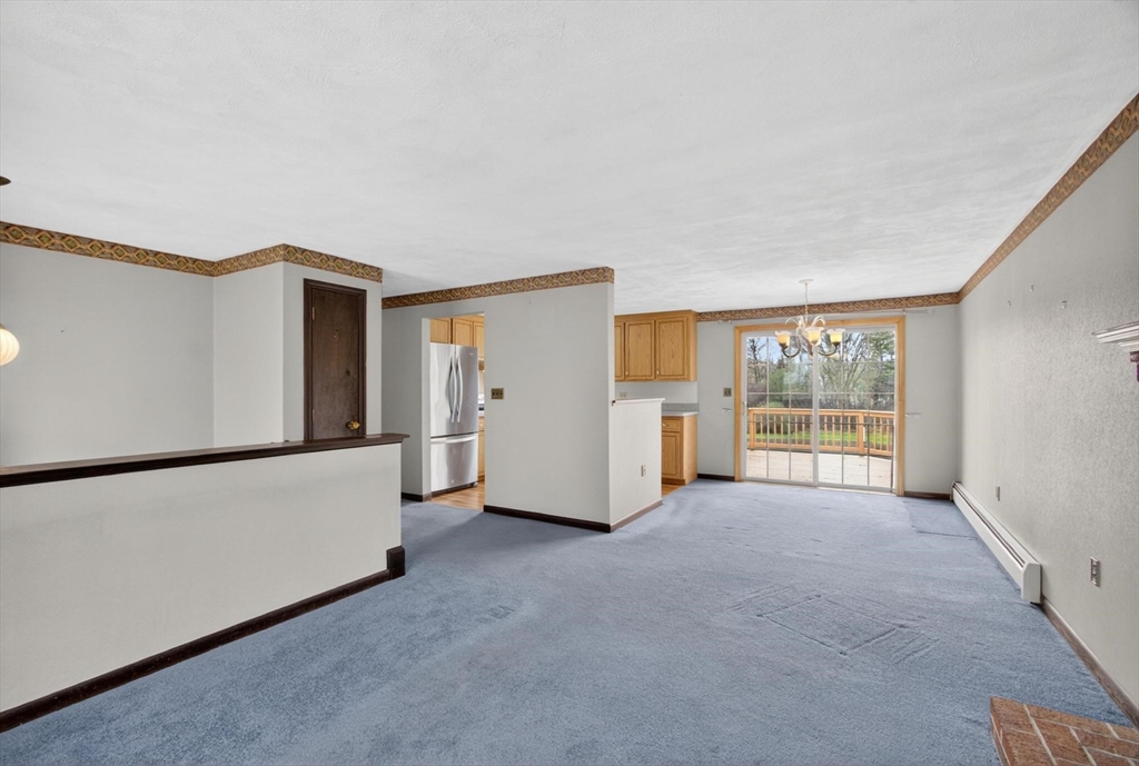 73 Nashua Road Pepperell, MA 01463 - Photo 7 of 33 a view of an empty room with a window and a kitchen