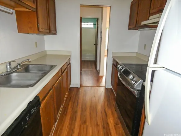 a kitchen with a sink a refrigerator and cabinets