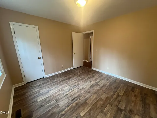 a view of empty room with wooden floor