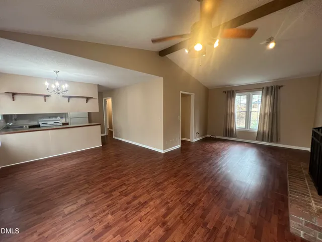 a view of a big room with wooden floor and windows