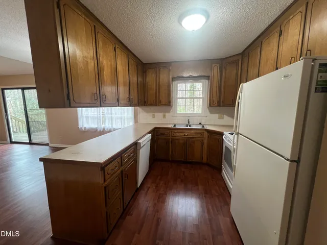 a kitchen with a refrigerator a sink a stove a microwave and cabinets