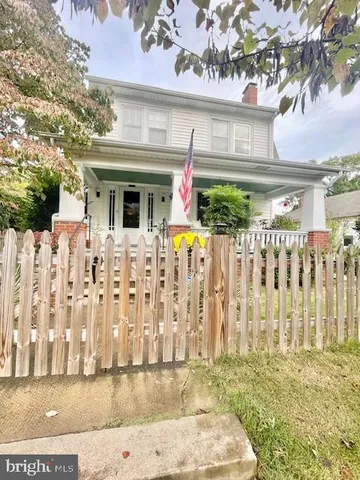 a front view of white house with a small yard
