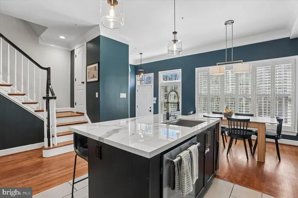 a kitchen with a sink and a stove top oven with wooden floor