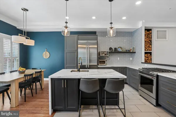 a kitchen with kitchen island a sink stove and refrigerator
