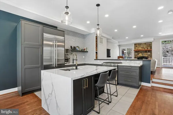 a kitchen with stainless steel appliances granite countertop kitchen island wooden floors and dining table