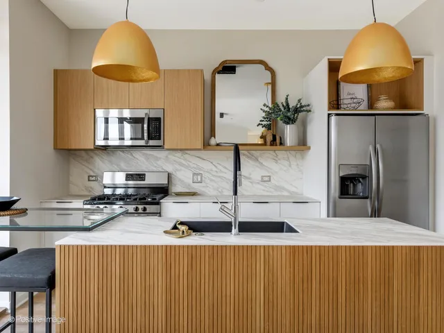 a kitchen with stainless steel appliances a stove a microwave a sink and cabinets