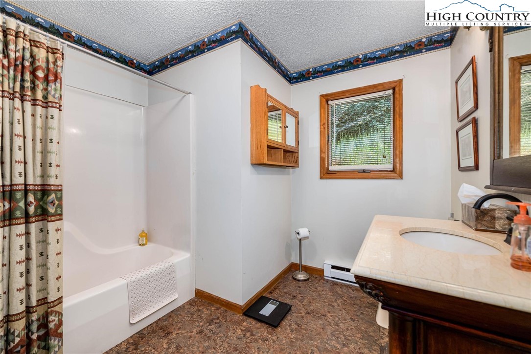 424 Poga Road Butler, TN 37640 - Photo 22 of 40 a bathroom with a sink a bathtub and a shower